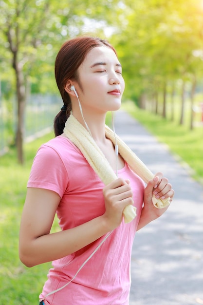 Photo woman listening music while standing on footpath