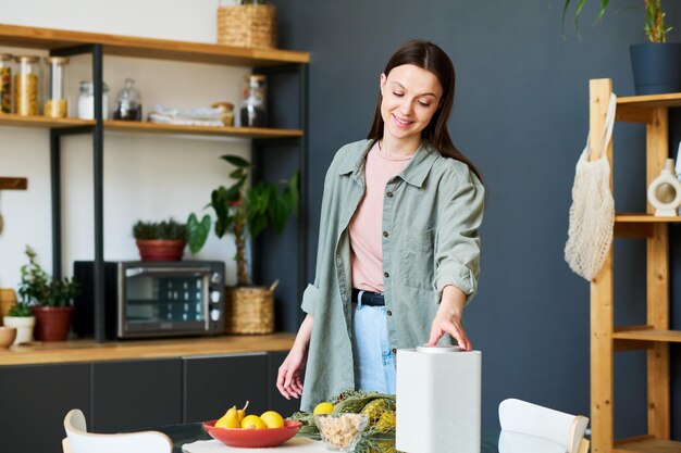 Woman listening to smart speaker in the kitchen