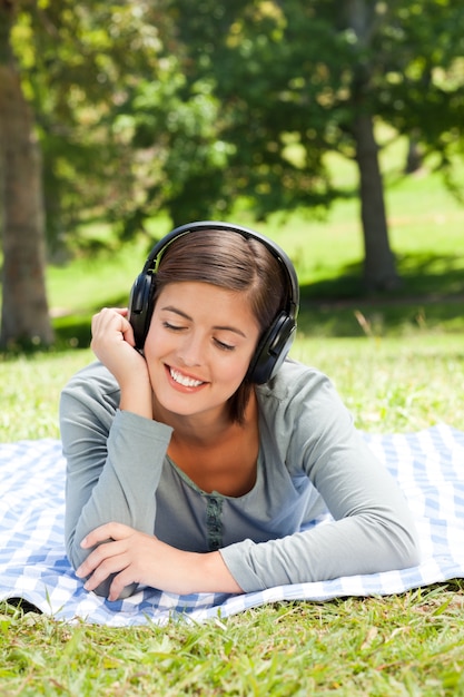 Женщина слушает музыку в парке