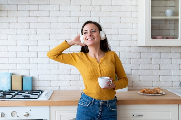 写真 女性が台所で音楽を聴く