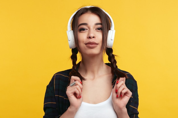 Woman listens music in white headphones isolated