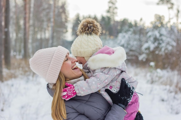 woman and little girl enjoy time together in snowy forest