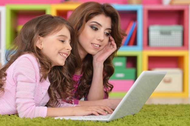 Woman and little girl using laptop
