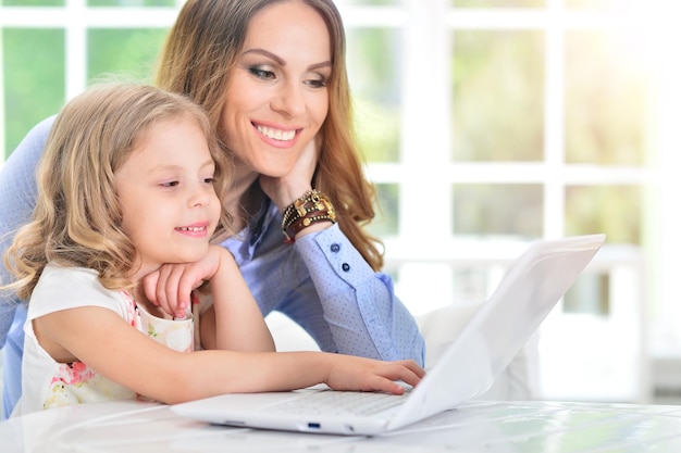 Woman and little girl using laptop