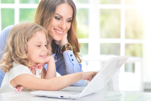 Woman and little girl using laptop