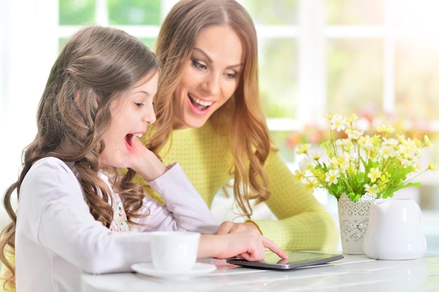 Woman and little girl using tablet