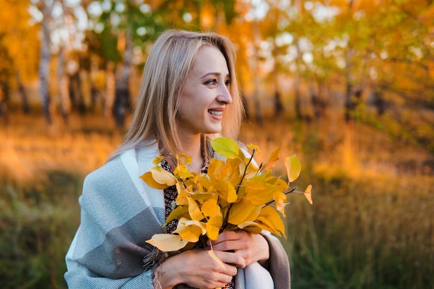 Foto la donna in un lungo cappotto nella foresta di autunno