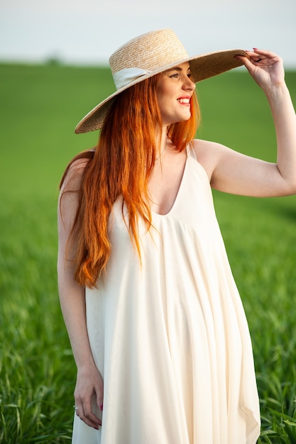 Woman in long white dress on a green field