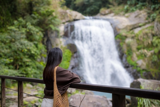 Женщина смотрит на прекрасный водопад