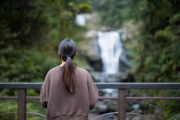 Woman look at the beautiful waterfall