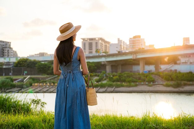 夕暮れの景色の下の街を眺める女性