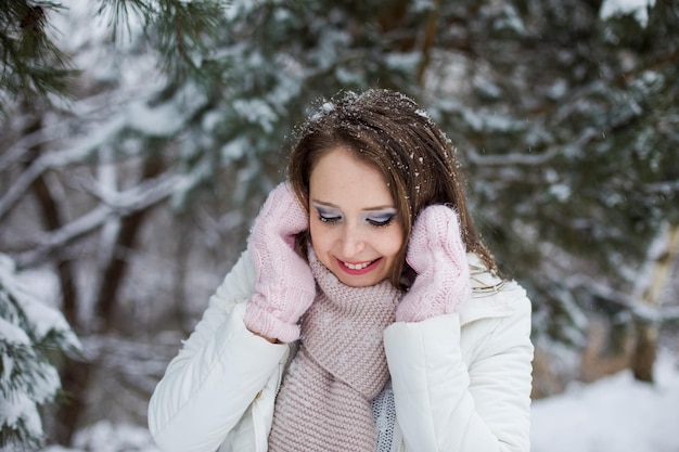Женщина смотрит вниз и много миль под заснеженной сосной Снег на ее ресницах