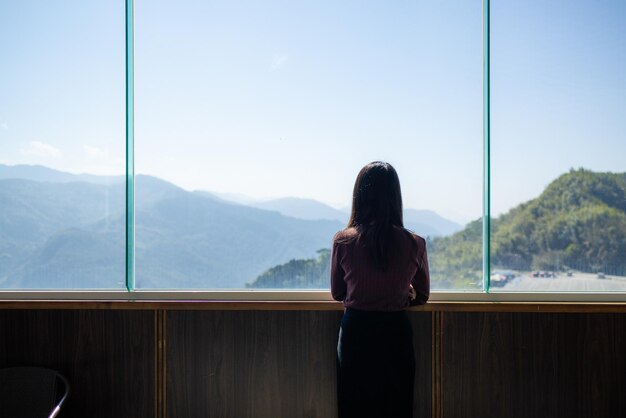 Foto la donna guarda il paesaggio di montagna all'interno dell'edificio