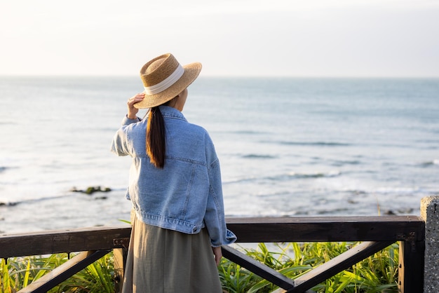 夕暮れの時の海を見る女性