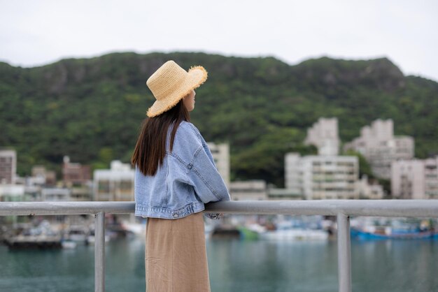 Photo woman look at the sea in yehliu fishing harbor