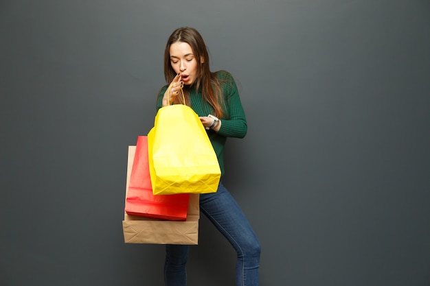 Woman looking in amazement at her shopping bags.