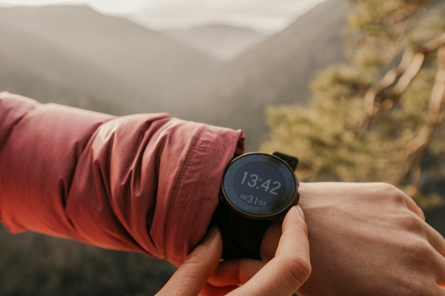 Foto donna che guarda l'app su sportwatch runner con cardiofrequenzimetro sportivo orologio intelligente controllo della posizione gps delle prestazioni o del polso della frequenza cardiaca