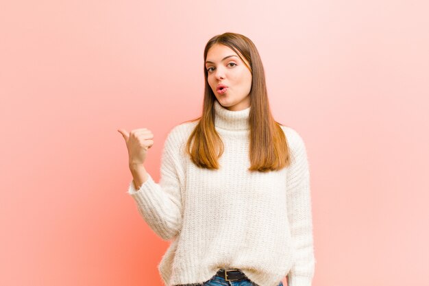 woman looking astonished in disbelief, pointing at object on the side and saying wow, unbelievable