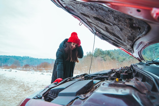 写真 車のエンジンのロードアシスタントを見ている女性