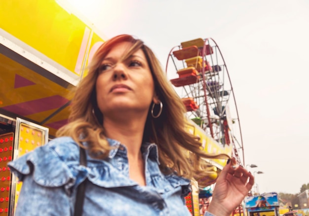 Woman looking away against ferris wheel