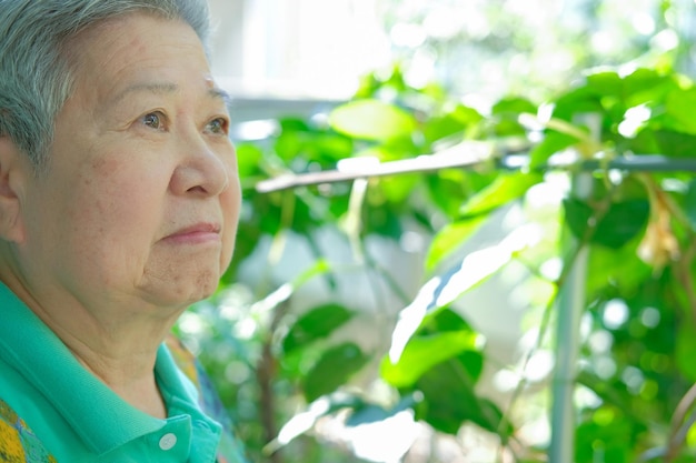 写真 植物の向こうから目をそらす女性