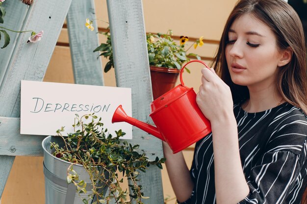 Photo woman looking away while holding potted plant