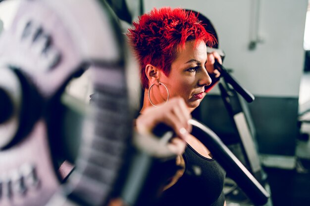 Woman looking away while sitting in gym