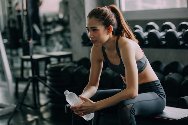 Woman looking away while sitting in gym