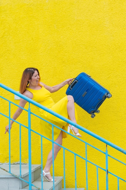 Woman looking away while standing against yellow wall