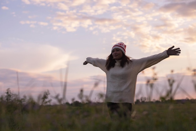 空に向かって草の上に立っている女性が目をそらしている