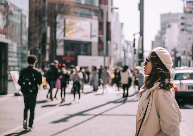 写真 街の通りで立っている女性が目をそらしている