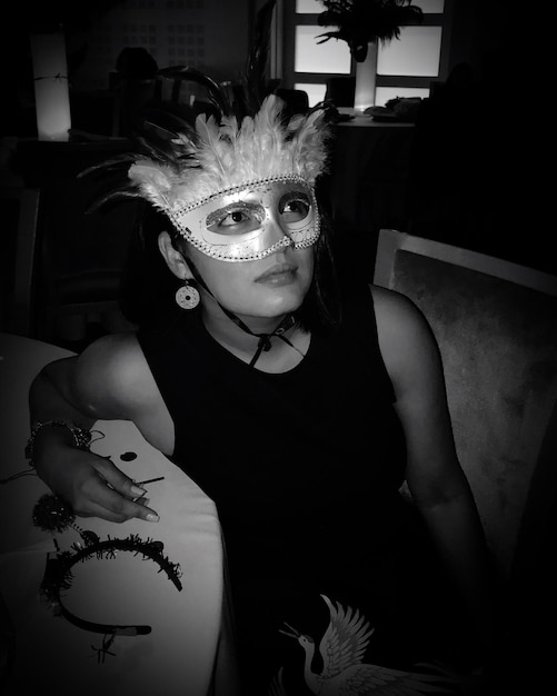 Foto donna che guarda da un'altra parte mentre indossa una maschera di notte