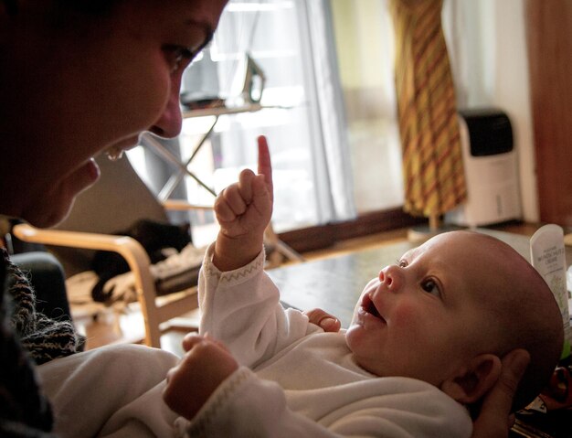 Foto donna che guarda il bambino a casa