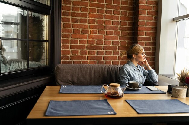 Photo woman looking at camera while sitting on table