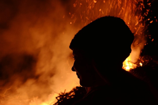 Photo woman looking at campfire at night