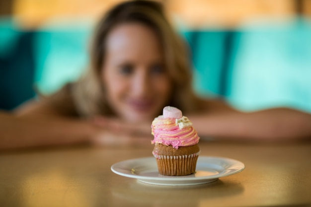 皿の上のカップケーキを探している女性