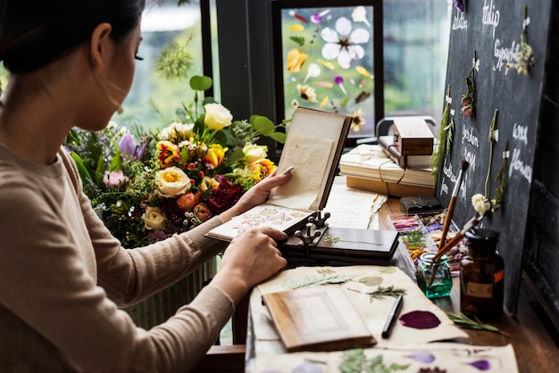 Woman looking a dried flower book