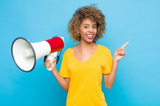 woman looking excited and surprised pointing to the side and upwards to copy space