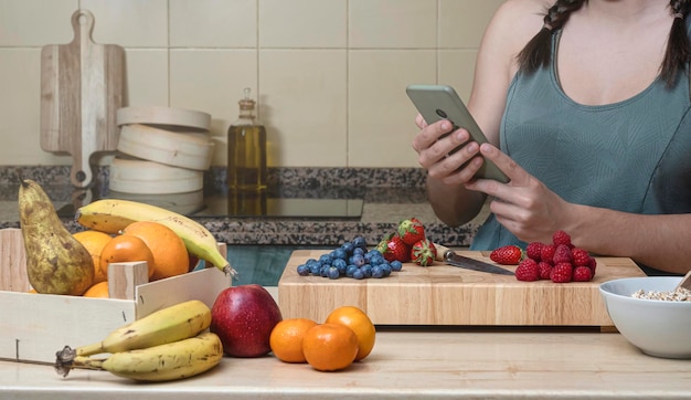 Woman looking at her cell phone in her kitchen