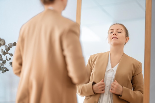 woman looking at her reflection in mirror