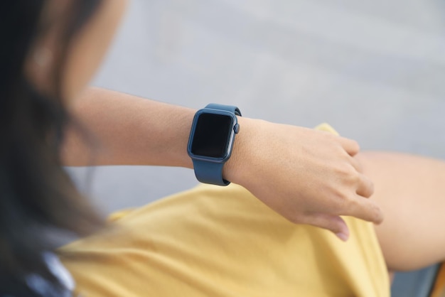 Photo a woman looking at her smartwatch on hand