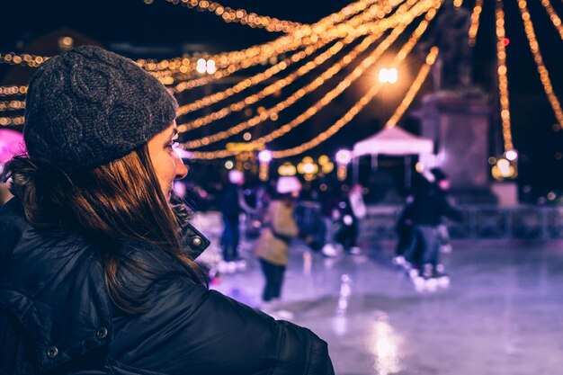 Foto donna che guarda il pattinaggio sul ghiaccio