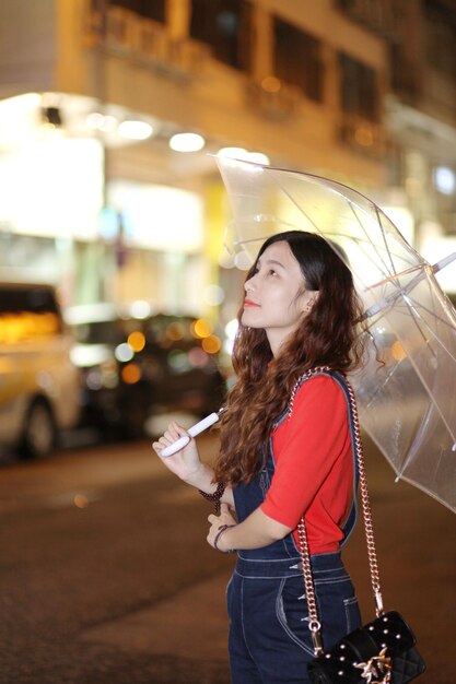 Photo woman looking at illuminated city at night