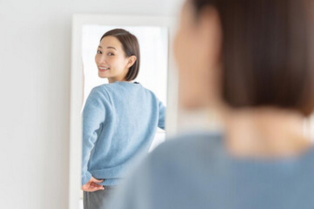 Photo a woman looking into a mirror and smiling