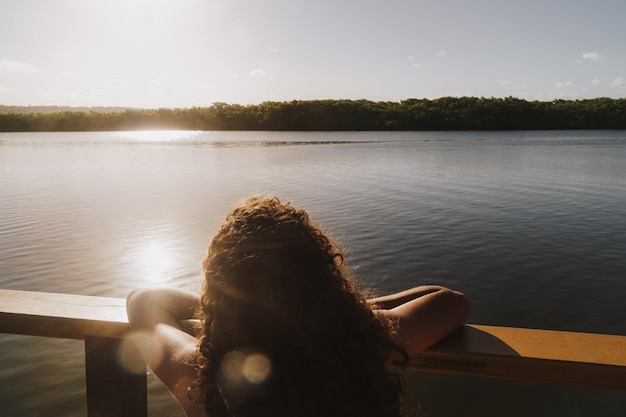 Photo woman looking at lake against sky during sunset