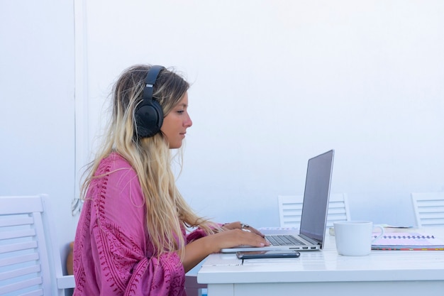 Woman looking at laptop teleworking side view