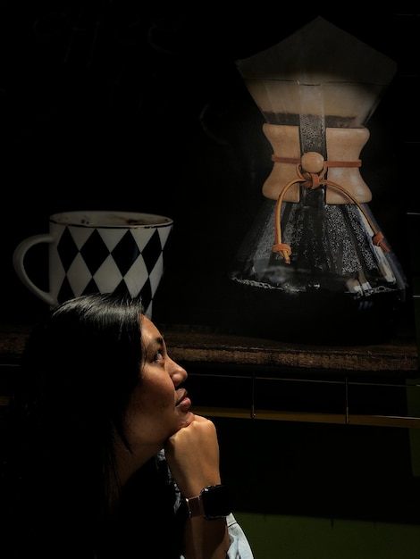 Foto donna che guarda un grande cassettiere sul tavolo nella camera oscura