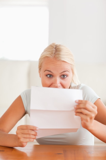 Woman looking at a letter in disbelief