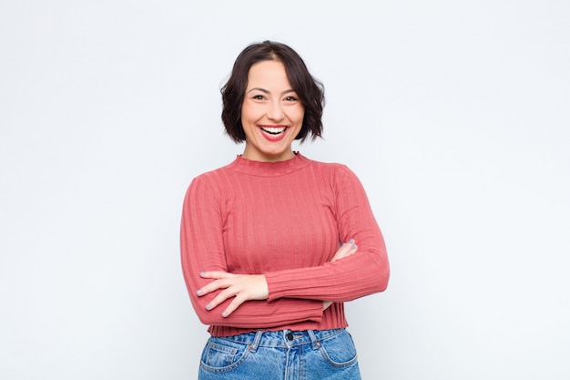 Woman looking like a happy, proud and satisfied achiever smiling with arms crossed