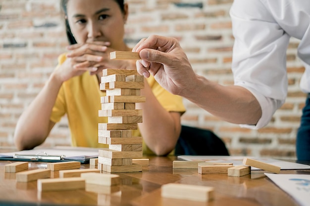 Photo woman looking at man stacking toy blocks at table